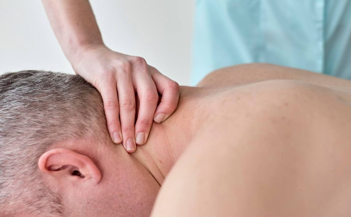 Séance de massage seniors maintien mobilité et articulation ciblant les cervicales et le haut du dos d'un homme aux cheveux poivre et sel.