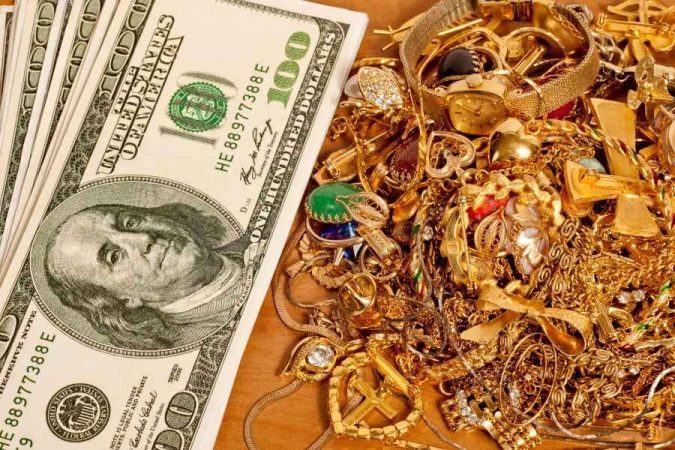 Un tas de bijoux anciens en or et des billets de cent dollars, illustrant le profit potentiel lors de la démarche pour vendre son or à Nice.